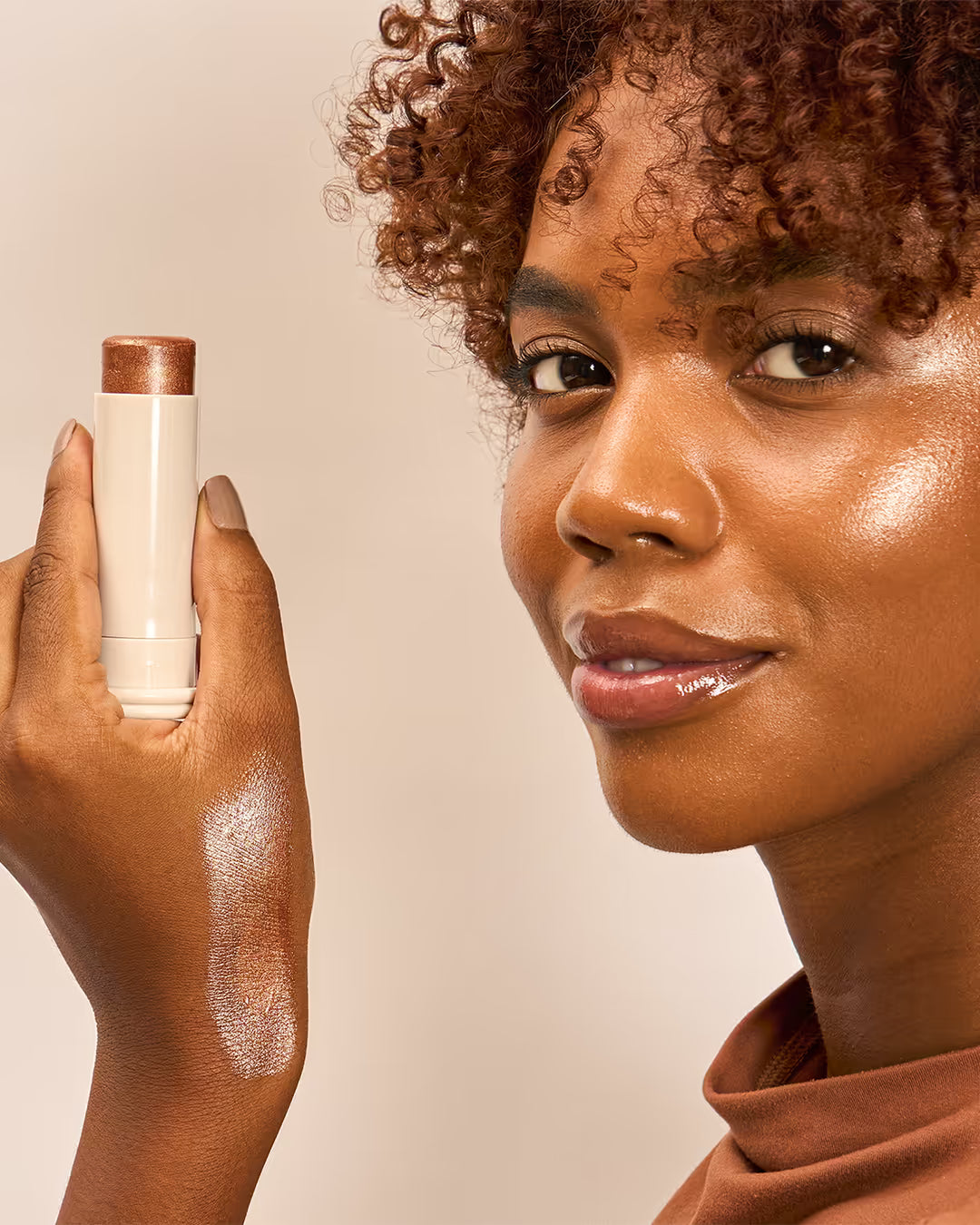 Iluminador facial e corporal vegano em bastão na cor dourada para um brilho radiante e natural aplicado na pele
