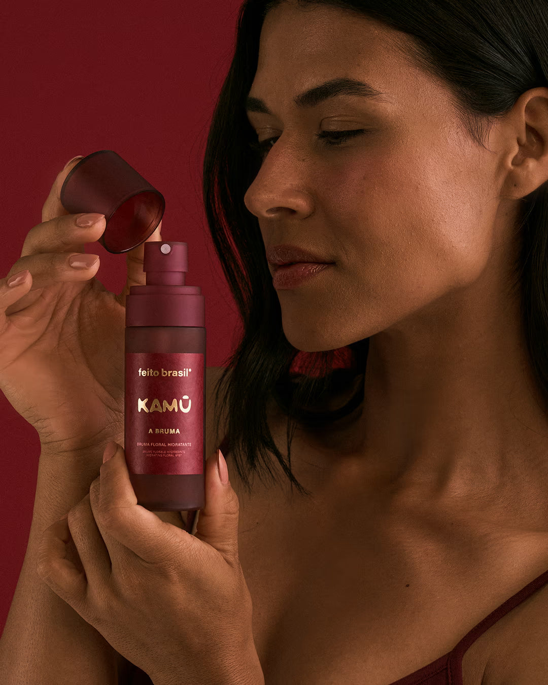 Modelo aplicando a Bruma Facial sobre a maquiagem para garantir fixação e acabamento natural.