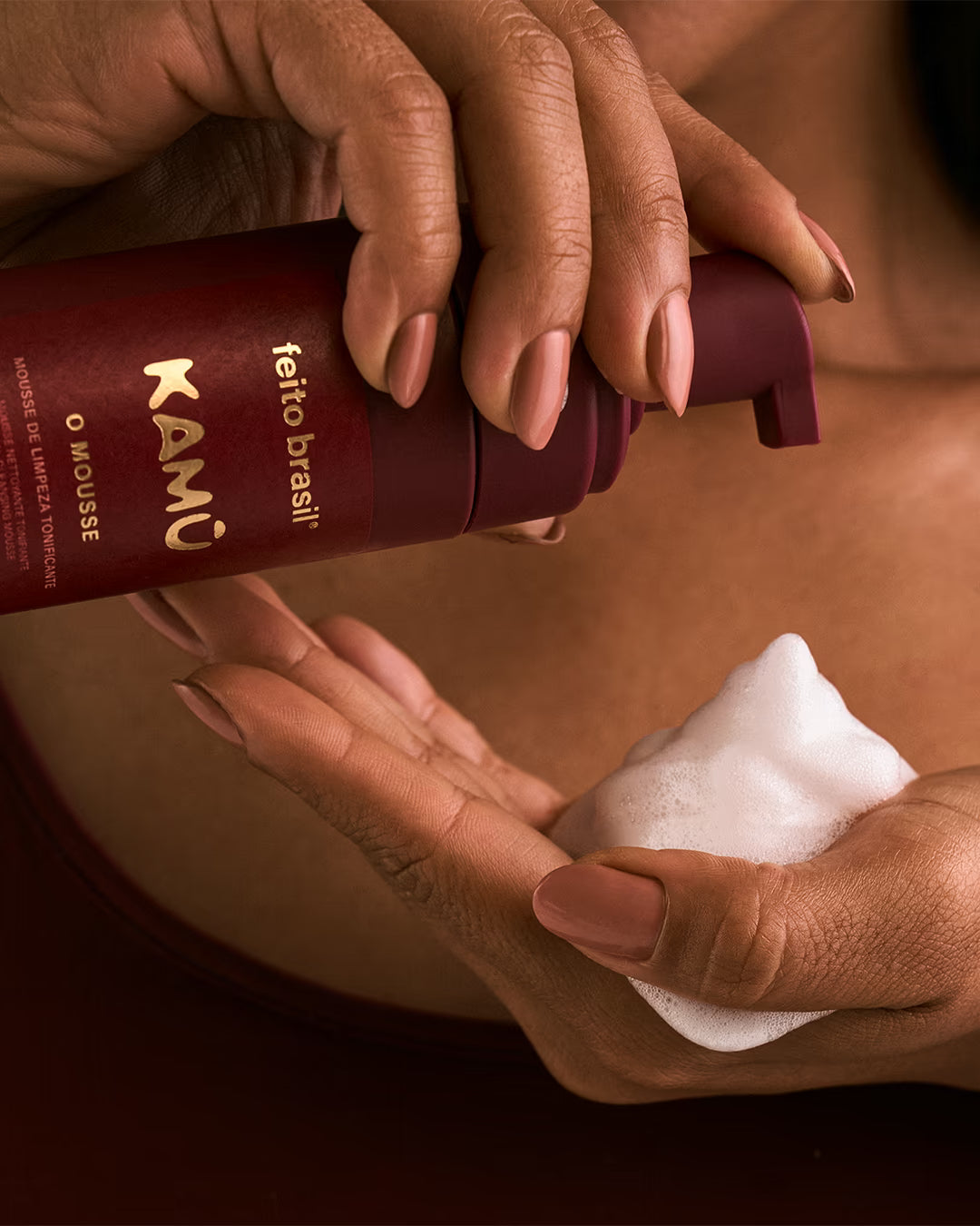 Detalhe da espuma branca, densa e cremosa do Mousse de Limpeza Facial nas mãos.
